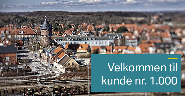 Billede af Køge set fra bugten. En farvelagt, firkanten boks er tilføjet. i boksen står der "Velkommen til kunde nr. 1.000".